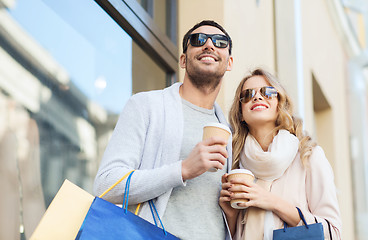 Image showing happy couple with shopping bags and coffee in city