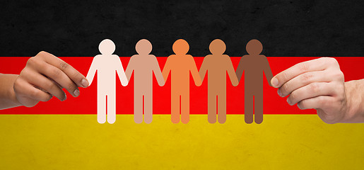 Image showing hands with paper people pictogram over german flag