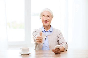 Image showing senior woman with smartphone showing thumbs up