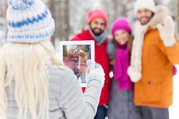 Image showing happy friends with tablet pc in winter forest