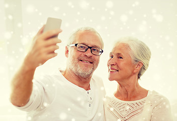 Image showing happy senior couple with smartphone at home