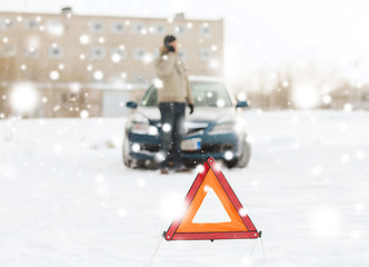 Image showing closeup of man with broken car and smartphone