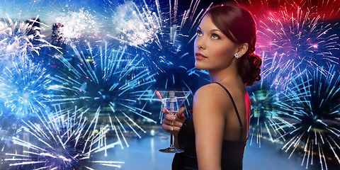 Image showing woman holding cocktail over firework in city