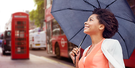 Image showing happy african woman with umbrella in london city