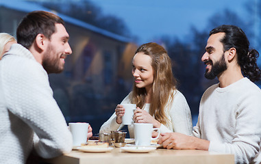 Image showing happy friends meeting and drinking tea or coffee