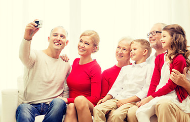 Image showing smiling family with camera at home