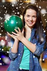 Image showing happy young woman holding ball in bowling club