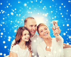 Image showing happy family with camera at home