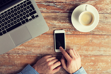 Image showing close up of hands with laptop and smartphone