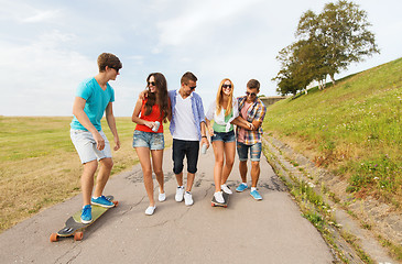 Image showing happy teenage friends with longboards outdoors