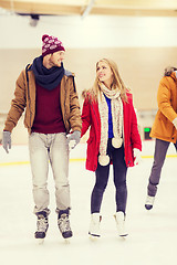 Image showing happy couple holding hands on skating rink