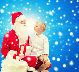 Image showing smiling little boy with santa claus and gifts