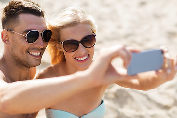 Image showing happy couple in swimwear walking on summer beach