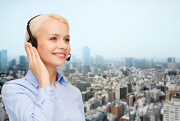 Image showing helpline operator in headset over city background