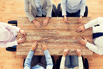 Image showing close up of business team sitting at table