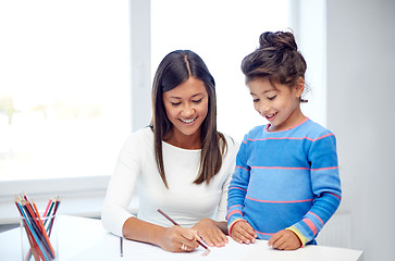 Image showing happy mother and daughter drawing with pencils