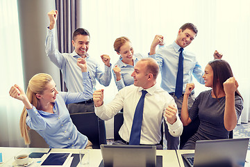 Image showing business people celebrating victory in office