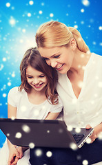 Image showing smiling mother and little girl with laptop