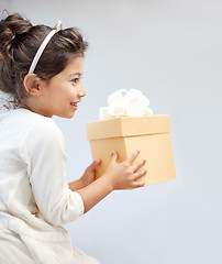 Image showing happy little girl with gift box at home