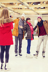 Image showing happy friends taking photo on skating rink