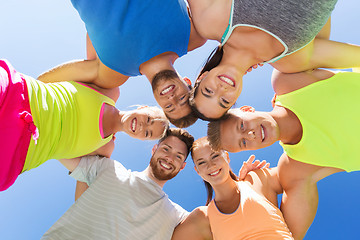 Image showing group of happy sporty friends in circle outdoors