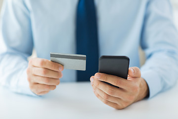 Image showing close up of hands with smart phone and credit card