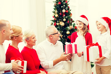 Image showing smiling family with gifts at home