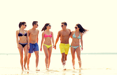 Image showing smiling friends in sunglasses on summer beach