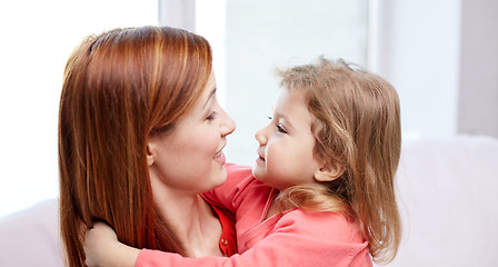 Image showing happy mother and little daughter hugging at home