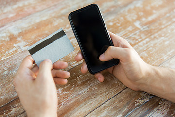 Image showing close up of hands with smart phone and credit card