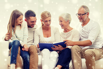 Image showing happy family with book or photo album at home