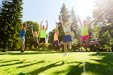 Image showing group of happy friends jumping high outdoors