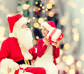 Image showing smiling little girl with santa claus and gifts