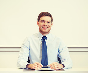 Image showing smiling businessman sitting in office