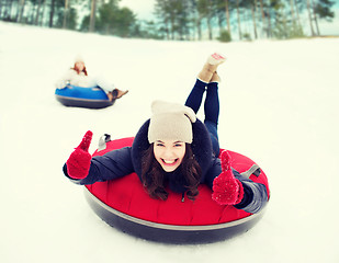 Image showing group of happy friends sliding down on snow tubes