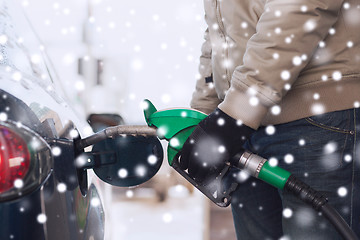 Image showing close up of man with fuel hose nozzle tanking car