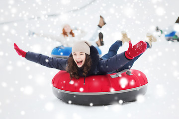 Image showing group of happy friends sliding down on snow tubes