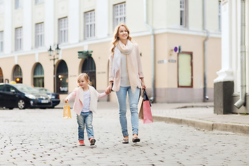 Image showing happy mother and child with shopping bags in city