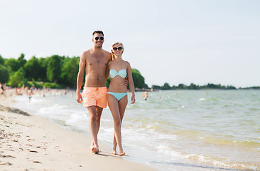 Image showing happy couple in swimwear walking on summer beach