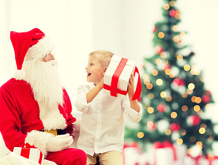 Image showing smiling little boy with santa claus and gifts