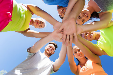 Image showing group of happy friends with hands on top outdoors