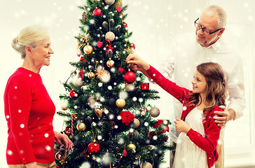 Image showing smiling family decorating christmas tree at home