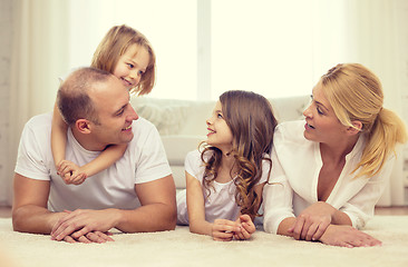 Image showing parents and two girls lying on floor at home