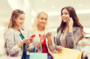 Image showing happy women with smartphones and shopping bags