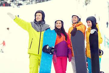 Image showing happy friends in helmets with snowboards