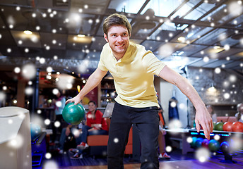 Image showing happy young man throwing ball in bowling club