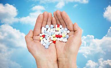 Image showing close up of senior woman hands with pills
