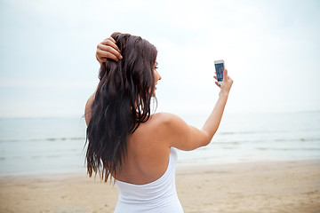 Image showing young woman taking selfie with smartphone