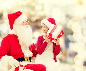 Image showing smiling little girl with santa claus and gifts