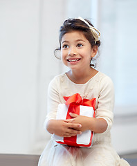 Image showing happy little girl with gift box at home